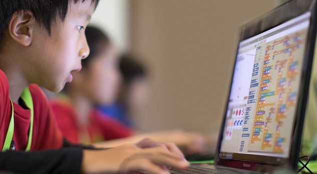 boy looking at computer with scratch blocks