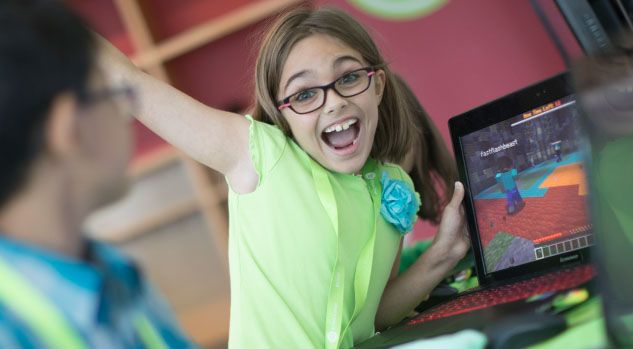 happy girl showing off computer with minecraft